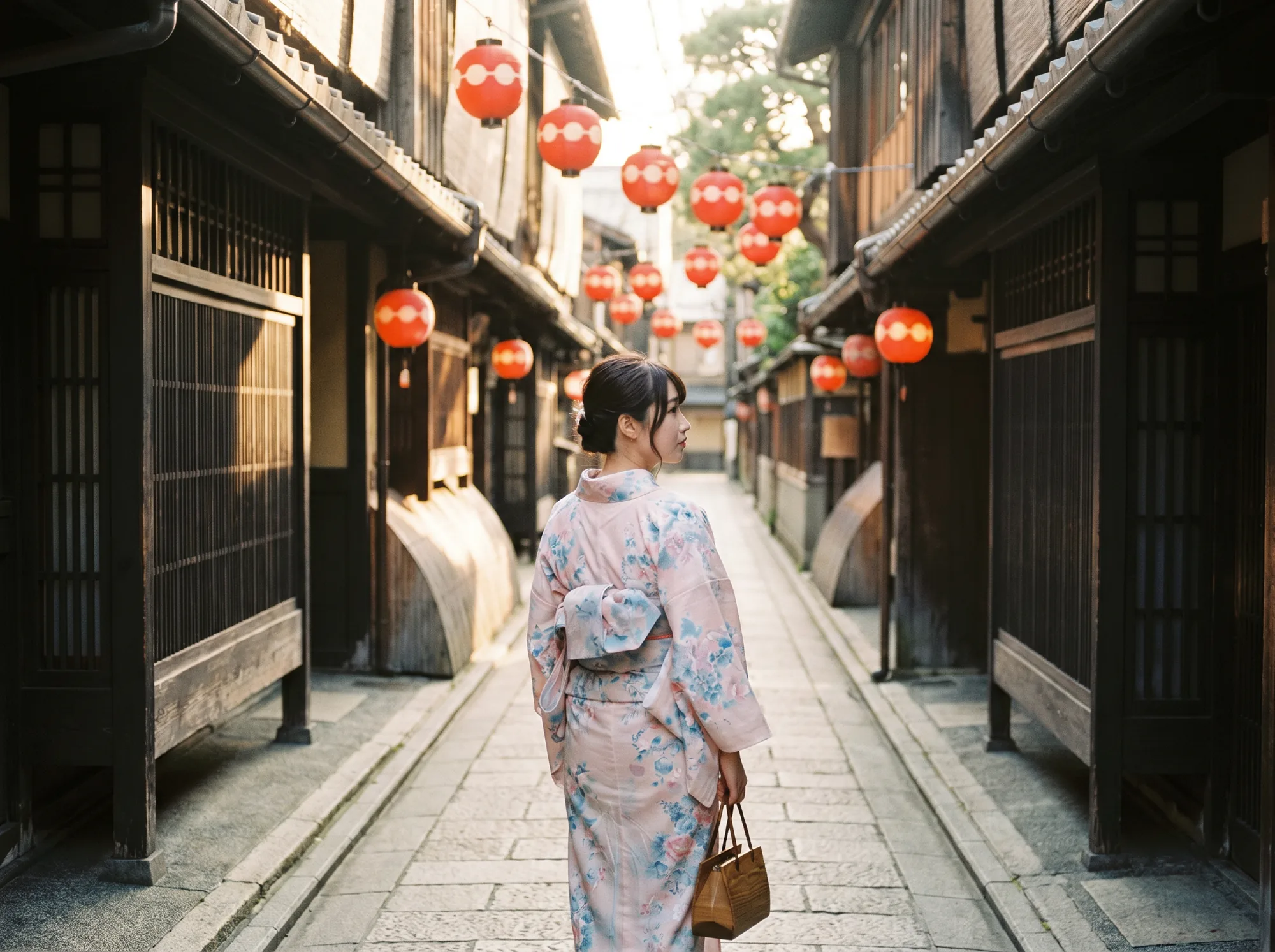 A traveler in kimono walking down a Kyoto stone alley